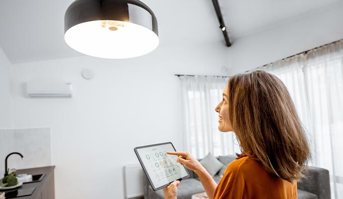 Woman controlling home lights with a tablet Woman controlling home lights with a tablet