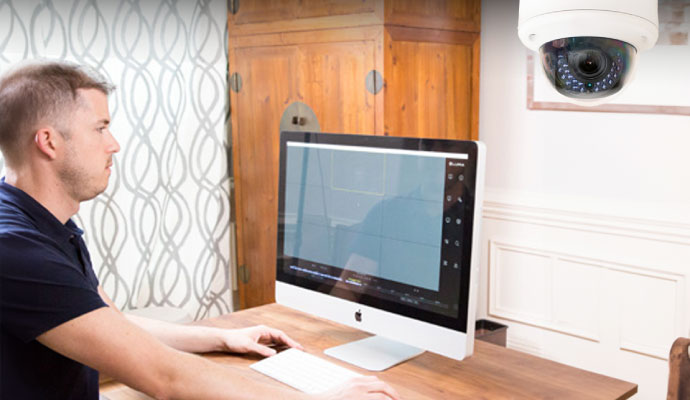 a person monitoring cameras on his computer