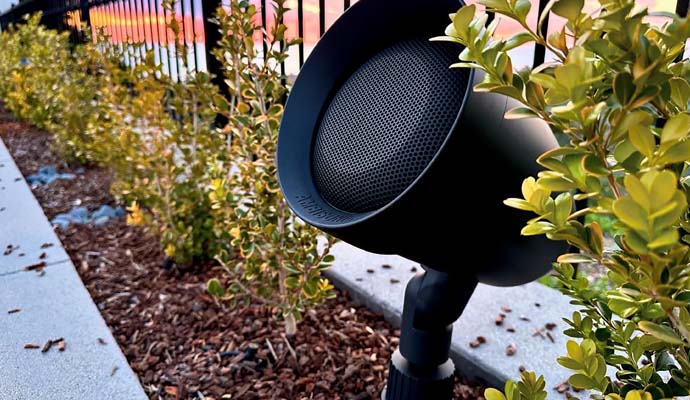 Black outdoor speaker mounted on a post