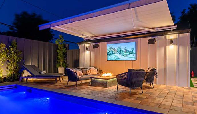 Outdoor entertainment setting with retractable awning