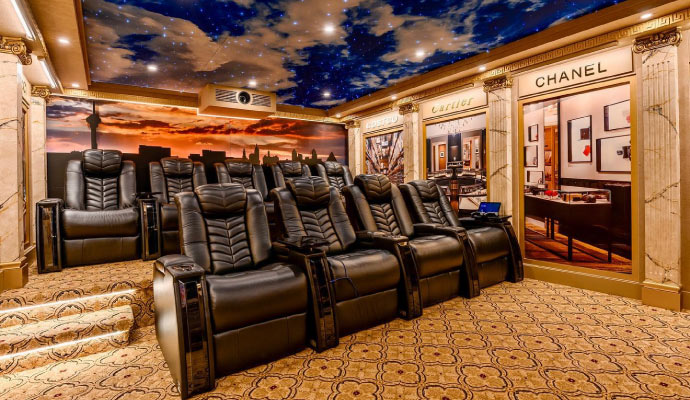  home theater room with black leather reclining seats and floor is covered with a patterned carpet